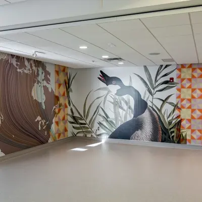 A view of an interior space at YGK Airport showing the 'Homecoming' art mural which features a goose, text and other elements.